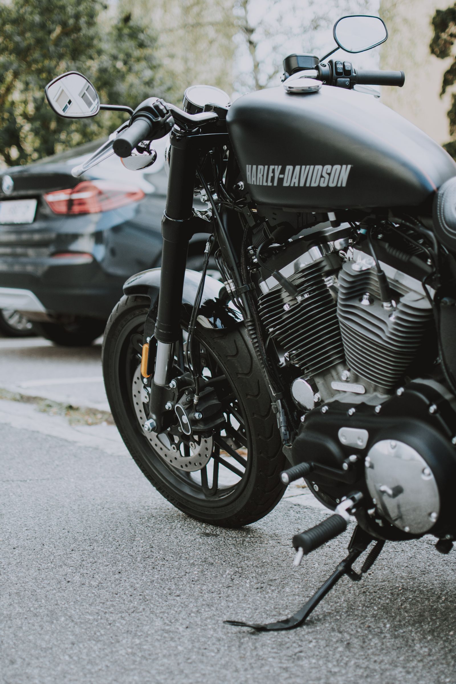 Matte-black Harley-Davidson Sportster with chrome V-twin engine, parked on a city street
